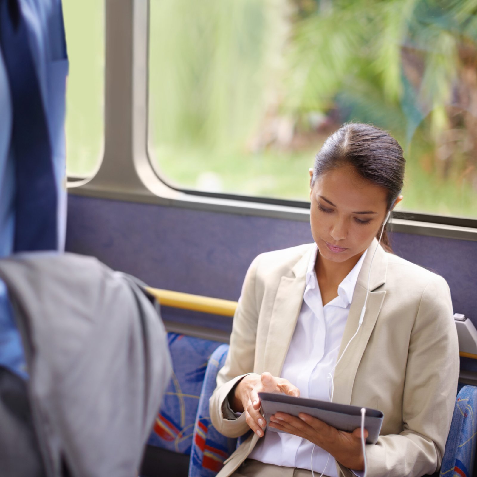 Shot of a businesswoman using a digital tablet while commuting on a bus.